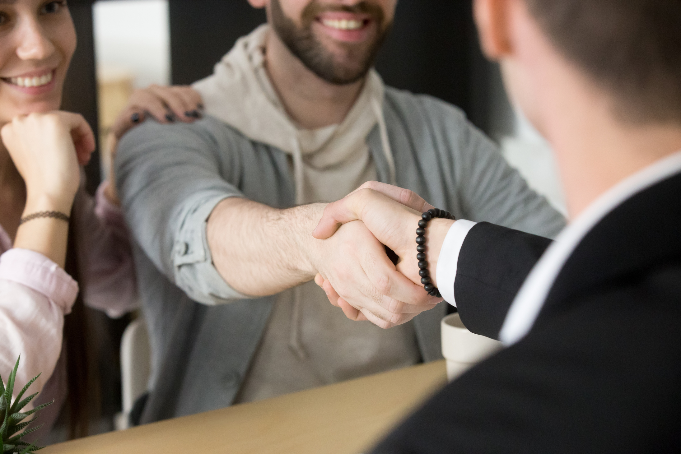 Satisfied couple handshaking Real Estate Agent closing successful deal